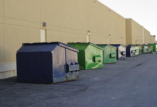 a construction worker moves construction materials near a dumpster in Dumfries